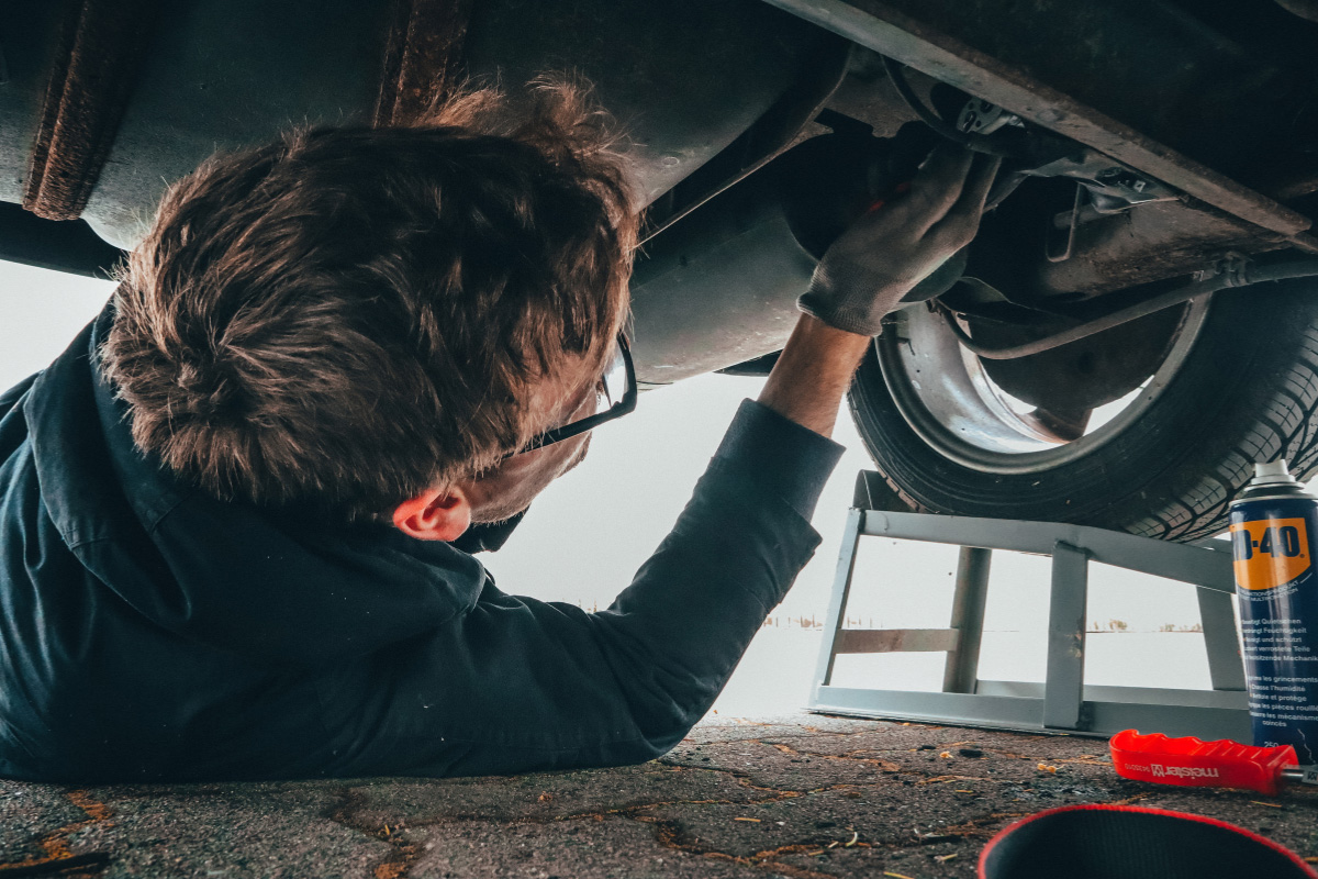 Mechanic assessing the underside of a car as part of our Camarillo emergency vehicle repair services.