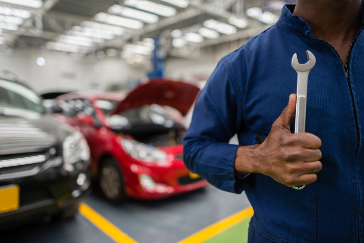 A mechanic holding a wrench while doing emergency auto repair near Dos Vientos Ranch, Thousand Oaks, California.